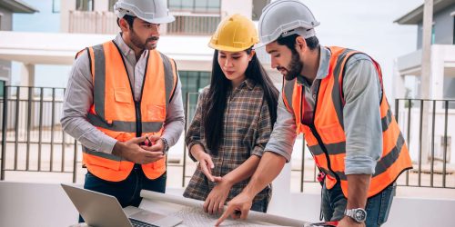 Civil engineer , Construction worker and Architects wearing hardhats and safety vests are working together at construction site ,building ,home in cooperation teamwork concept.